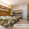 Una camera da letto per quattro persone con letto matrimoniale e letti a castello.