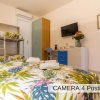 Camera con letto matrimoniale e letti a castello, TV a schermo piatto e decorazioni floreali.