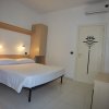 Stanza luminosa con letto matrimoniale e arredi minimalisti.