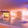 Spa con piscina interna, archi metallici e cascate d'acqua.
