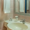 Un bagno con lavabo bianco, asciugamani appesi e specchio grande.