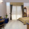 Camera da letto con letto matrimoniale, scrivania blu e grandi finestre con tende a righe.