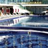 Piscina con lettini e ombrelloni rossi.