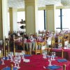 Ristorante con tavoli apparecchiati e tovaglie rosse.