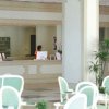 Lobby dell'hotel con sedie verdi e reception.