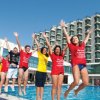 Ragazzi saltano felici vicino a una piscina.