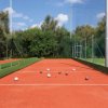 Campo da bocce con diverse bocce sul terreno rosso e verde.