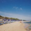 Una spiaggia con lettini e ombrelloni blu.