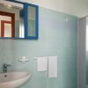 Bagno con lavabo, specchio blu e doccia.