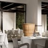 Ristorante elegante con tavoli apparecchiati e grandi finestre.