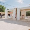 Spazio esterno con tavoli bianchi e decorazioni naturali.