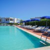 Piscina con accesso tramite scaletta e ombrelloni blu.