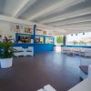 Sala lounge con sedute bianche e pareti blu.