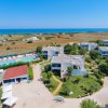 Vista aerea di un resort con piscina vicino al mare.