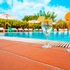 Due cocktail a bordo piscina con lettini e ombrelloni sullo sfondo.