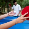 Due persone giocano a ping pong all'aperto.