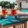 Due bicchieri di cocktail accanto a una piscina con lettini.
