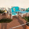 Set da giardino con divani e tavolo azzurri su terrazza.