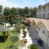 Un giardino con sentiero, gazebo e edificio bianco.