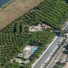 Vista aerea di un campeggio con pini e piscina.