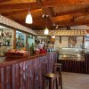 Bar con bancone di legno e scaffali di liquori.