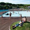 Piscina affollata con persone che si rilassano intorno.