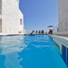Una piscina all'aperto tra edifici bianchi.