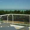 Balcone con vista su alberi e mare.