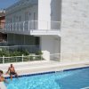 Persone rilassate a bordo piscina di un edificio moderno.