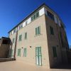 Edificio angolare con persiane verdi, cielo blu.