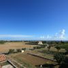 Paesaggio rurale con campi e cielo azzurro.