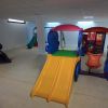 Area giochi interna con scivoli colorati.