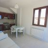 Cucina moderna con tavolo bianco e divano.