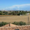 Panorama di campagna con campi e case in lontananza.