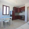 Cucina moderna con tavolo bianco e sedie intorno.