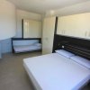 Camera da letto con letto matrimoniale e armadio chiaro.