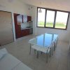 Sala luminosa con cucina e tavolo da pranzo.
