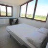 Camera da letto con grandi finestre e scrivania.