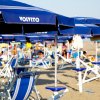 Ombrelloni blu su una spiaggia affollata.