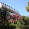Edificio tra alberi e fiori con una struttura moderna.