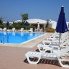 Piscina all'aperto con lettini e ombrelloni blu.