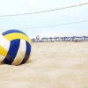Palla da pallavolo sulla sabbia vicino a una rete da beach volley.