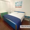 Camera con letto matrimoniale, coperte blu, due comodini e decorazioni alle pareti.