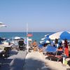 Una spiaggia con ombrelloni blu e bianchi, vista mare.
