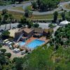 Veduta aerea di un campeggio con piscina e camper parcheggiati.