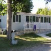 Una casa mobile con recinzione bianca.