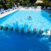 Piscina con sdraio, una persona nuota al centro.