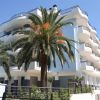 Edificio moderno con palme, balconi curvi.