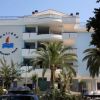 Edificio moderno con balconi e palma davanti.