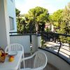 Balcone con tavolo, sedie e vista su alberi e strada.